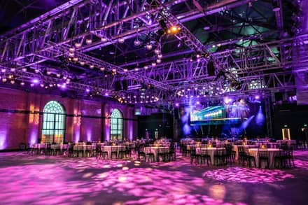 Function space setup for an awards evening dinner with stage, lights, and screen
