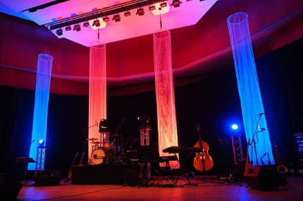 Musical instruments setup on stage with red and blue lighting