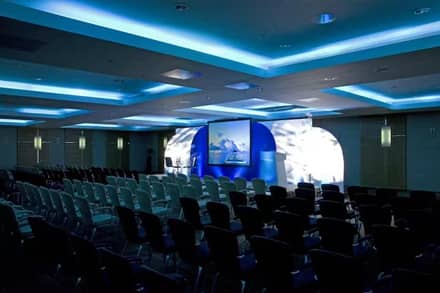 Conference room setup for a brand launch with stage and screen at a Hilton hotel