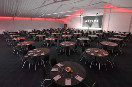 Large conference space in a cabaret setup with screen at Easthampstead Park