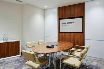 Modern meeting room setup for a small training session with screen at a Marriott hotel