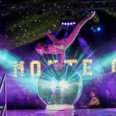 Show Performer Balancing on a Glitter Ball Photo